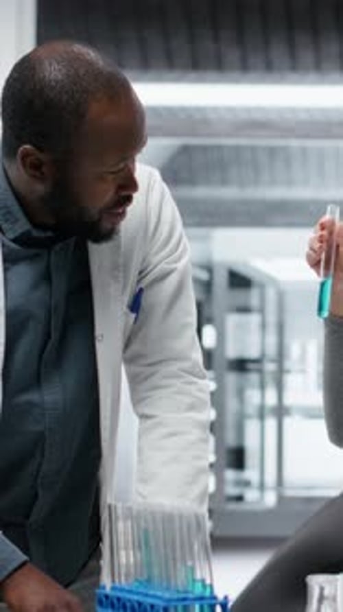 Vidéo verticale Les technologues de laboratoire clinique en laboratoire évaluent des solutions composées