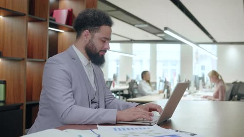Un homme d'affaires travaille avec diligence dans un environnement de bureau de coworking moderne
