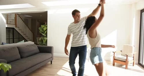 Young Couple Dancing and Laughing in Living Room
