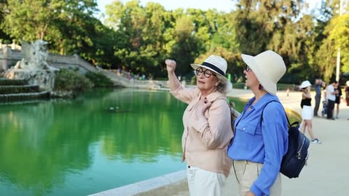 Senior female friends exploring park and sharing stories