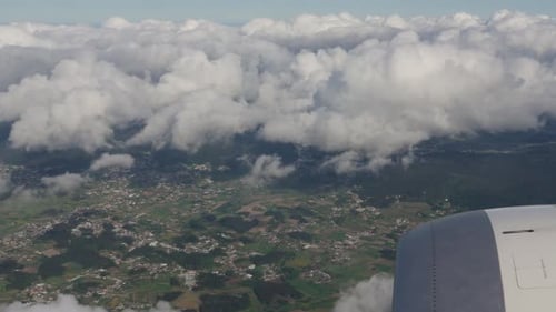 Wolken- und Landschaftsblick aus dem Flugzeug während des Fluges über der ländlichen Gegend