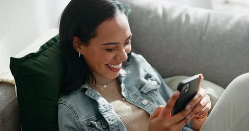 Woman Relaxing on Couch Using Mobile Phone
