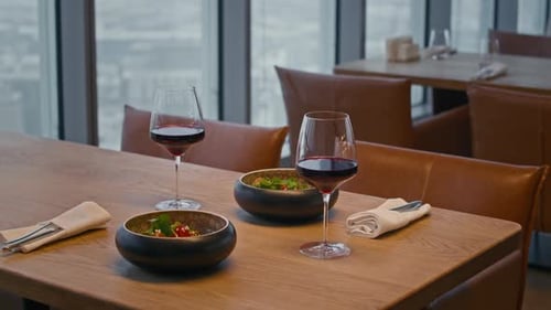 Glasses of Red Wine and Main Dish on Table in Modern Lounge