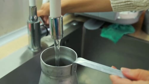 Young Woman Preparing Coffee in Modern Kitchen