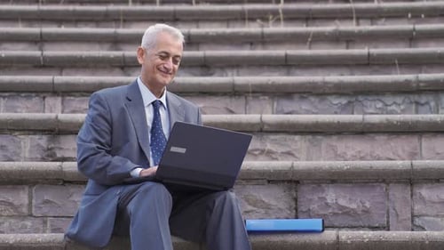 Mature Adult Working on Laptop on Steps