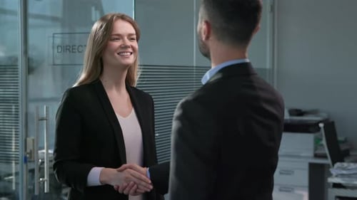 Handshaking of Office Workers at Meeting in Glass Interior of Office. Business