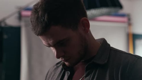 Focused Photographer Checking Digital Camera Settings in Photo Studio