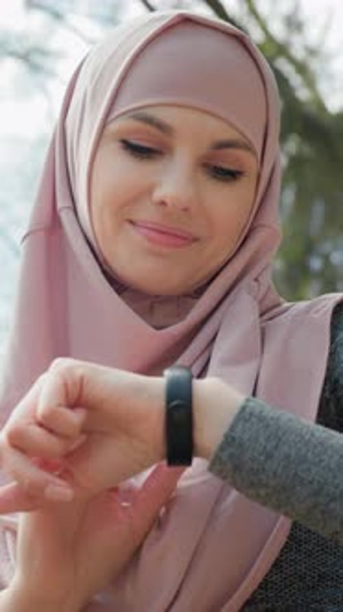 Smiling Woman Checking Smart Watch Outdoors