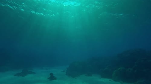 soleil éclatant sous l'eau en profondeur Océan avec éblouissement du soleil sur le fond marin et ondulations à la surface des vagues