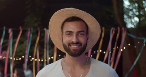 Smiling man in hat at outdoor party