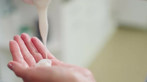 Lotion or cream poured onto a woman's hand