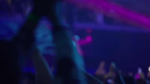 Blurred Crowd Silhouettes Raising Hands at Concert Event