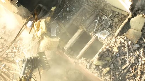 Vue aérienne rapprochée d'une griffe d'excavatrice nettoyant les gravats et les matériaux isolants lors d'une démolition