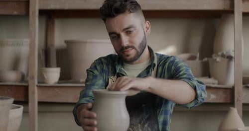 Zoomin of Skilled Young Man Wearing Dirty Apron Making Vase From Clay in Pottery Workshop