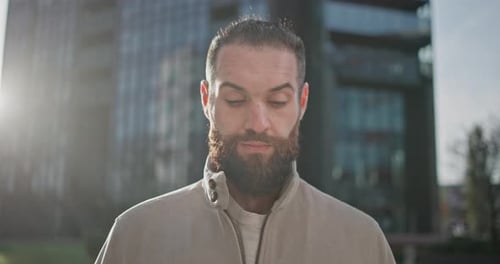 Bearded Man Looks Up in Urban Setting