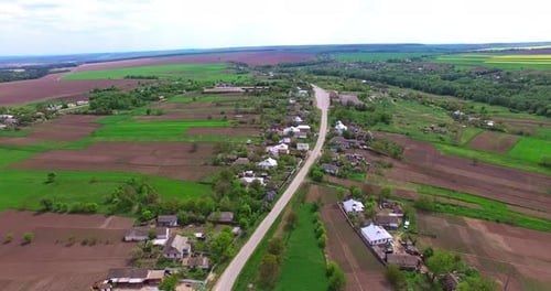 Road going through the village up to the farmlands. Lovely panorama of a rural countryside