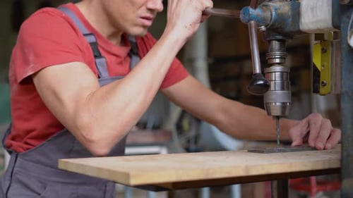 Faceless Carpenter Drilling Steel in Professional Workshop
