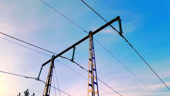 Power line tower from below against blue sky in golden hour. SLOW ...