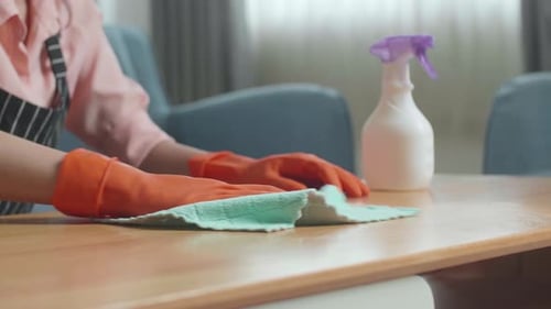 Close Up Of Female Housekeeper's Hands Cleaning The Table By The Spray At Home