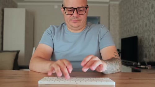 Man Typing on a Wireless Keyboard at Desk