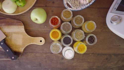 Above Shot of Bottles with Different Spices and Other Ingredients Vegetables and Kitchen Utensils
