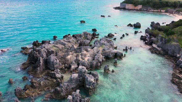 Aerial view of sharp pointy rocks in turquoise water by tropical island ...