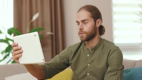 Close Up Serious Man Using Tablet Computer Having Online Conversation with His Colleague Friend