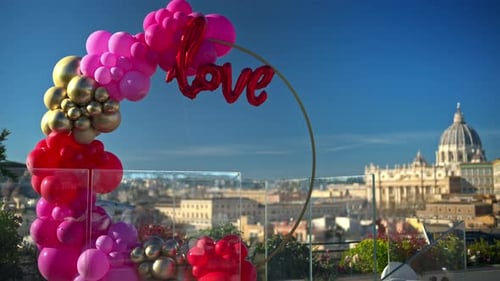 Pink, red and gold, love balloon arch at panoramic view of Vatican City, Rome, Italy.