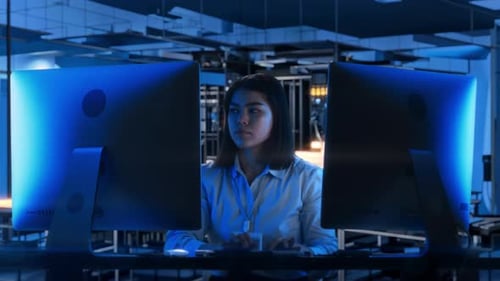 Female IT Specialist Working on Computer in Data Center