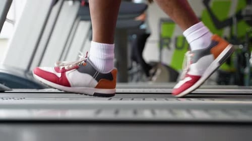 Young African American Man Running on Treadmill at Gym Close Up of Legs