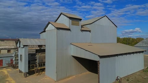 Farm with silo grain storage elevator in countryside. Small agriculture industry family business.