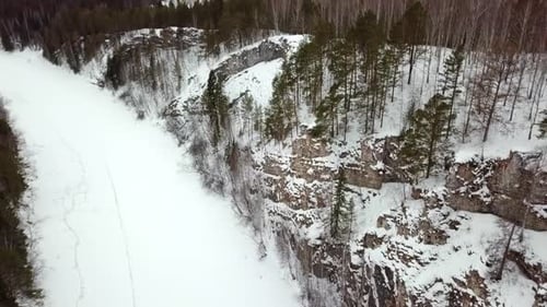 A Picturesque Snowy Landscape Showcasing Majestic Rocky Cliffs Adorned with Lush Pine Trees Stock