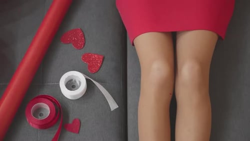 Woman in Red Dress Holds a Gift on Couch