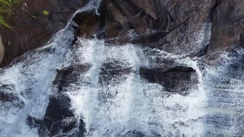 Lateral camera movement with drone filming a beautiful waterfall very close, flowing waters