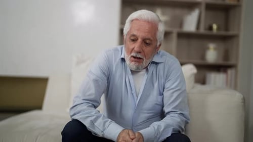 Un homme âgé se sent mal et a une toux terrible, un homme âgé aux cheveux gris souffrant d'asthme
