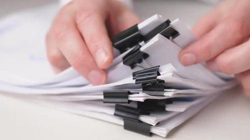 Businessman Hands Searching Information in Stack of Papers Files on Work in Office