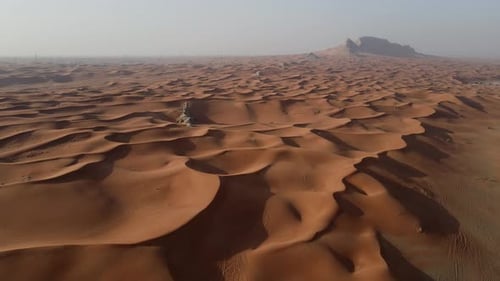 Wide Cinematic Aerial View of Vast Rolling Orange Sand Dunes