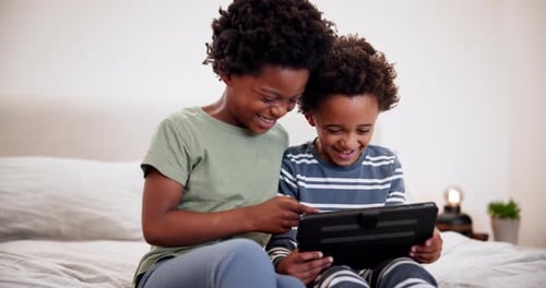 Children Interact With Tablet on Bed