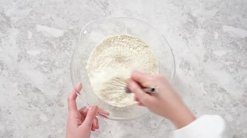 Flat Lay Mixing Ingredients in a Glass Mixing Bowl to Bake Funfettti Bundt Cake