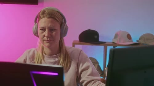 Blonde Girl in Headset Gamer Drink Water During Online Game