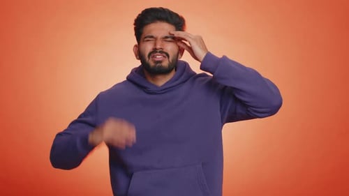Man Rubs Temples in Discomfort
