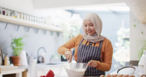 Woman Whisking Ingredients in a Bright Kitchen