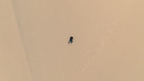 A lost man in the golden sands of the desert landscape