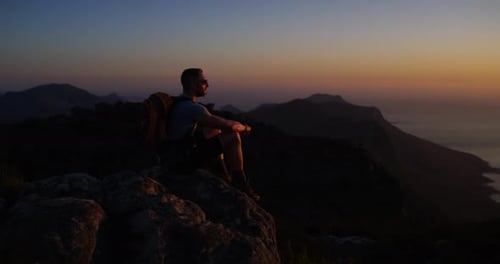 Man, hiking and sunset for view, night and mountain top over ocean, climber and adventure