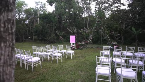Outdoor Wedding Ceremony Setup with White Chairs
