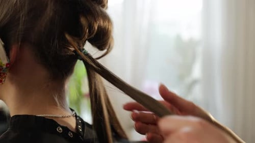 Professional Hairdresser Curling Woman's Hair with Iron