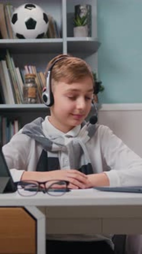 Little Cute Boy in Headphones Having a Video Call Talking Using Laptop Sitting in the Living Room