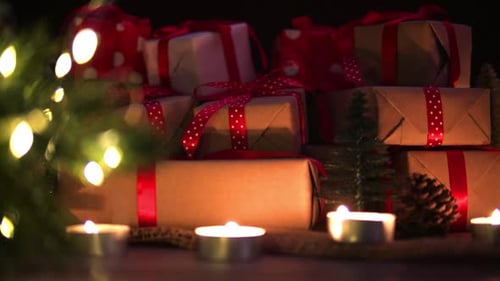 Christmas Gifts Stacked Near Glowing Candles