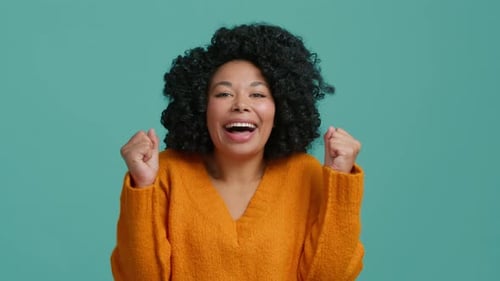 Aufgeregte Afroamerikanerin mit lockigem Haar in Zeitlupe, die laut schreit, Studio