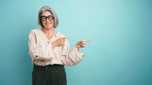 Elegant Senior Businesswoman Pointing at Copy Space